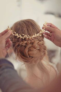 a woman is getting her hair done with some gold chains on top of her head