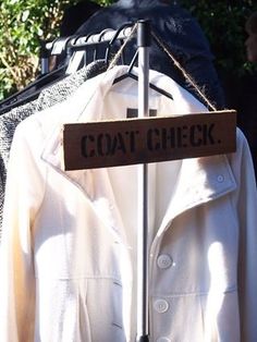 a coat is hanging on a clothes rack with a sign that says, coat check