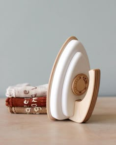 a stack of folded towels sitting on top of a wooden table next to a clock