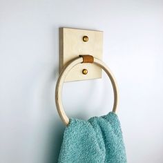 a towel hanging on the wall with a wooden ring