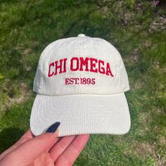 a person holding a white hat with a red embroidered on it Chi Omega Merch, Sorority Beanie, Sorority Merch Ideas, Corduroy Hats, Sorority Accessories, Omega Alpha, Embroidered Corduroy, Delta Chi, Alpha Sigma Tau