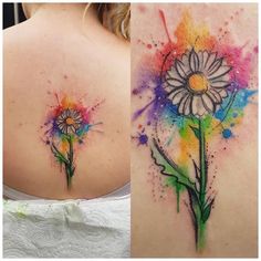 the back of a woman's shoulder with watercolor tattoos on her left side