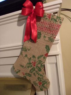 a christmas stocking hanging from the side of a fireplace with a red bow on it