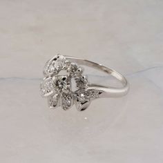 Vintage 18K White Gold 1ct Diamond Cocktail Ring, 1/4 ct center brilliant cut, round diamond 12 diamond single cut surround in an asymmetrical floral design, H SI 1,.5 inch across, Ring size 7.75, Circa 1960, 5.2 grams SKU# BB331R10 This listing contains photographs of the actual item you will receive. Our items are in excellent condition with little or no signs of wear and many are one of a kind pre-owned estate finds. Please look closely at the pictures in this listing as they are part of the Diamond Cocktail Ring, Diamond Cocktail Rings, Ring Ideas, Fine Jewelry Designers, Yellow Gold Earring, Multi Stone Ring, Multi Stone, Ring Size 7, Cocktail Ring