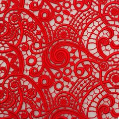 an intricate red lace fabric with circles and stars on the center, is seen in this close up photo