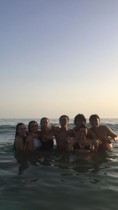 a group of people in the water posing for a photo