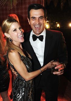 a man in a tuxedo standing next to a woman wearing a sequin dress