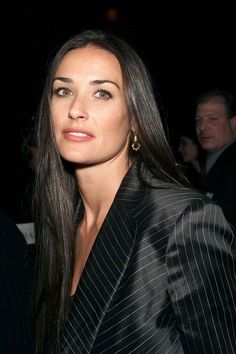 a woman in a pinstripe blazer posing for the camera at an event