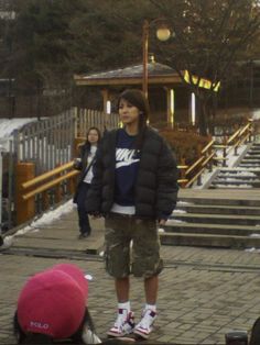 a young man standing on top of a brick walkway