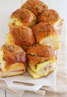 ham and cheese sliders on a white platter with napkins next to them