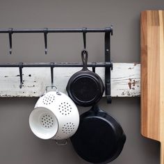 pots and pans are hanging on a rack