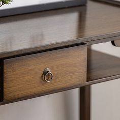 a close up of a desk with a plant on it and a phone in the drawer