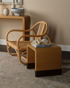 a chair and table with a book on it in front of a wall mounted mirror