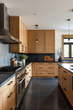 a kitchen with wooden cabinets and black counter tops, along with an island in the middle