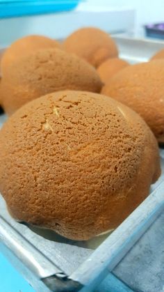 some kind of bread that is in a tray on a table and ready to be eaten