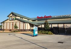 an empty parking lot in front of a family kitchen with a sign on the building