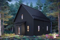 a small black house surrounded by trees and bushes at night with lights on the windows