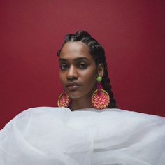 a woman with braids wearing large earrings