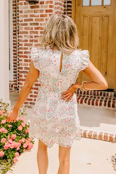 - Stroll through a field of wildflowers and twirl under the sun in this enchanting mini dress! Its flattering silhouette and delicate eyelet embroidery captures the essence of a summer daydream! - Fully lined sheer embroidered floral eyelet material with a pink and blue hued floral print -A round neckline with back button closure and a keyhole detail - Short flutter sleeves - Back zip closure - A flattering silhouette that ends in a straight mini dress length hemline Summer Floral Embroidered Dress For Brunch, Floral Embroidered Dress For Summer Brunch, Spring Floral Dress With Lace Trim For Brunch, White Ditsy Floral Print Dress For Spring, Summer Floral Dress With Ditsy Print For Garden Party, Spring Floral Dress With Lace Trim For Garden Party, Summer Mini Dress With Flutter Sleeves For Garden Party, Spring Ditsy Floral Print Garden Party Dress, White Floral Embroidered Dress For Garden Party