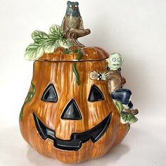 a ceramic pumpkin container with an owl sitting on top