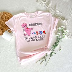 a pink t - shirt that says teacherssauruss like a normal teacher but more awesome