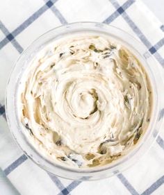 a bowl filled with cream cheese on top of a checkered table cloth