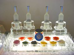 an ice tray with several bottles and bowls of food on it, including condiments