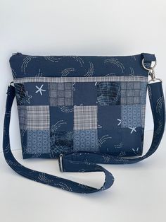 "Discover the \"Miami\" - a multi-pocketed, lightweight shoulder/crossbody bag that gives you plenty of organized space without an oversized look.  This Miami is done in coordinated deep federal blue and white cotton prints.   There are three generous accented exterior pockets - the front pocket composed of a coordinated patchwork of matching blue prints.  On the back are two accented pockets matching the basic bag fabric.    Inside are three slip pockets plus a zippered pocket on a white dot print lining.   The adjustable and detachable shoulder strap can be customized to standard or crossbody lengths.   Comfortably fits the iPad mini tablet (>8\") or standard kindle.  Fully lined.  Top zipper closure.   12\" WIDE // 9\" HIGH // 2\" WIDE  Made with 100% cotton fabrics.   Brushed silver-to Navy Crossbody Shoulder Bag For Travel, Navy Crossbody Shoulder Bag For Everyday Use, Blue Travel Shoulder Bag With Zipper Pouch, Versatile Rectangular Shoulder Bag With Flat Pocket, Daily Use Crossbody Shoulder Bag With Flat Pocket, Navy Shoulder Bag With Pockets For Everyday Use, Everyday Rectangular Shoulder Bag With Flat Pocket, Navy Bags With Pockets For Everyday Use, Rectangular Travel Shoulder Bag With Flat Pocket