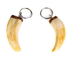 two banana shaped keychains are hanging from metal hooks on a white background with clippings