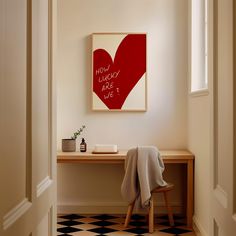 there is a red heart on the wall next to a desk and chair in this room