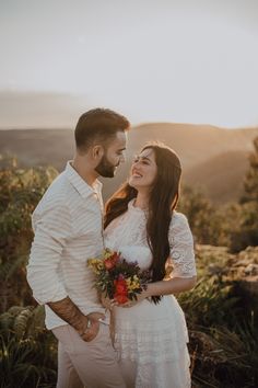 a man and woman standing next to each other in front of the sun at their wedding