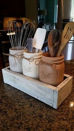 mason jars with utensils in them sitting on a counter