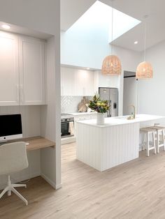 an image of a kitchen with white cabinets and wood flooring in the middle of it