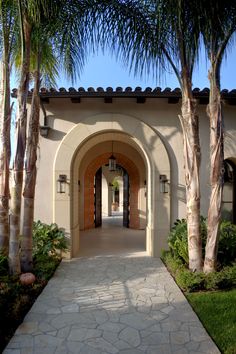 the entrance to a home with palm trees