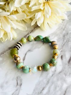 "Love this beautiful mix of colors and textures! Features 10mm Aqua Terra Jasper, 11mm Olive Green Ghana Recycled Glass, 8mm Grey Bone Mala Disc, Turquoise nuggets, 8mm carved Bone Prayer beads, 10mm Flower Jade, 11mm Speckled Ceramic, 11mm AB Faceted Glass Crystal and accented with African Brass. Bracelet fits 6.75\"-7.25\" Size is customizable, just let me know. Strung on high quality stretch cord and tied with a double surgeons knot and hypo cement  Thank you Wendy" Green Bohemian Stretch Bracelet For Everyday Wear, Green Hand Wrapped Beaded Bracelets For Everyday, Earthy Green Beaded Bracelets For Everyday, Earthy Green Jewelry With 8mm Beads, Bohemian Green Stretch Bracelet With 8mm Beads, Green Bohemian Stretch Bracelet With 8mm Beads, Everyday Green Stretch Bracelet With 8mm Beads, Green Natural Stones Bracelet For Everyday, Surgeons Knot