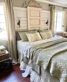 a large bed sitting next to two windows in a bedroom