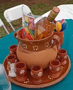 there is a vase with many items in it on top of a tray at the table