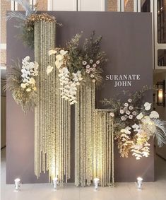 a display with flowers and candles in front of a sign that says sufranate john