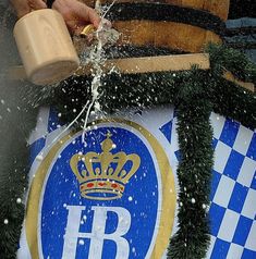 a person pouring water on top of a blue and white sign