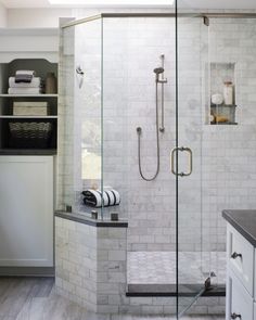 a walk in shower sitting next to a bathroom sink and counter top under a skylight