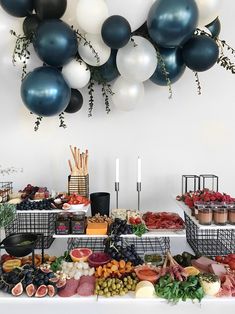 a buffet table filled with lots of food and balloons