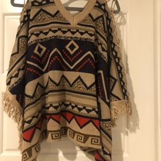 Tribal Sweater Poncho Os Never Worn Laces Up On Shoulders One Size Winter Festival Tops, Winter Festival One Size Tops, Casual Fall Beach Cape, Casual Cape For Fall Festival, Casual Fall Festival Cape, Beige Batwing Sleeve Poncho For Fall, Long Sleeve Fringe Poncho, Casual Beige Long Sleeve Cape, Beige Long Sleeve Bohemian Cape