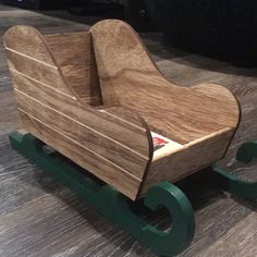 a wooden toy sleigh sitting on top of a hard wood floored floor