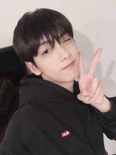 a young man making the peace sign with his fingers