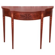 an oval shaped table with two drawers on one side and three legs, inlaid to the top