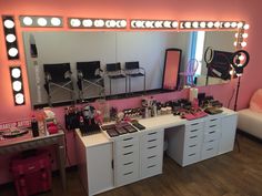 a vanity with lights and makeup on it