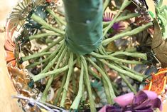 a vase filled with green beans and purple flowers