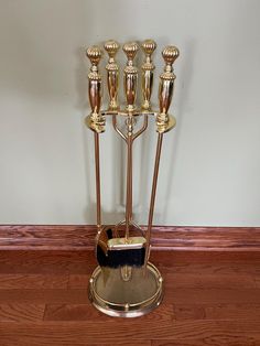 a gold candelabra with five candles on it sitting on a wooden floor