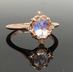 14K Moonstone and Diamond Ring- METAL: 14K Rose Gold TOTAL WEIGHT: 2.4 g (approximate, varies per size) DIAMONDS: Four Bezel Set Round Brilliant Cut Diamonds COLOR: G/H CLARITY: VS2 GEMSTONE: Oval Cut Rainbow Moonstone MEASUREMENTS: 5mm x 7mm SIZE: Ladies Size 4-12. Please indicate your ring size at checkout. DESCRIPTION: This ring is a beauty! The faceted moonstone has a play of color that is impossible to capture in a picture--it's so pretty! The Rainbow Moonstone is set in the center of an or Rose Gold Moonstone Ring, Rainbow Moonstone Engagement Ring, Moonstone Engagement Ring Set, Gemstone Wedding Rings, Wedding Ring Sizes, Moonstone Engagement, Zierlicher Ring, Moonstone Engagement Ring, Bridal Ring Sets