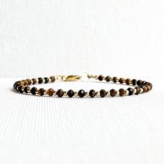 Tiger's Eye Bracelet  Finished with a lobster clasp. *BRACELET LENGHT- 6.0, 6.5, 7.0, 7.5, 8.0, 8.5 Inches* * MATERIALS & DIMENSIONS * * Tiger Eye Beads: about 3 mm - Grade AAA * Gold Filled or Sterling Silver Beads: about 2.0 mm * Gold Filled or Sterling Silver Findings * Premium Strong Flexible Beading Wire *Arrives in a gift box* Choose Your Bracelet Length Use a tape measure. Wrap the tape measure around the wrist on which you plan to wear your bracelet. Make a note of the number at the point where the tape meets the 0. To ensure the bracelet fits comfortably, add 1/2 or 1 inch depending on how tight or loose you like to wear your bracelet. I gladly accept returns Contact me within: 3 days of delivery Returns & exchanges accepted within 30 days Buyers are responsible for return shippin Tiger Eye Bracelet, Bracelet Dainty, Clasp Bracelet, Tiger Eye Beads, Eye Beads, Minimalist Bracelet, Beading Wire, Eye Bracelet, Healing Bracelets